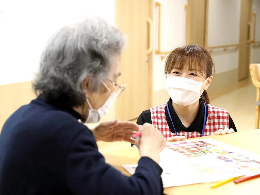 高齢者女性に笑顔で話しかける介護士